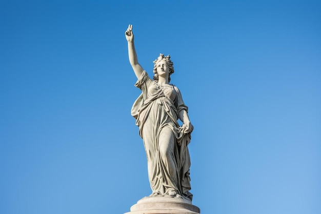 Photo a statue of a woman with a crown on her head is standing in front of a blue sky
