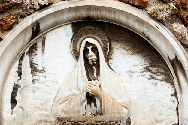 A statue of a woman with a face on it with the word jesus on it.