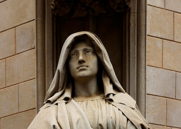 Foto una statua di una donna con un lungo cappuccio