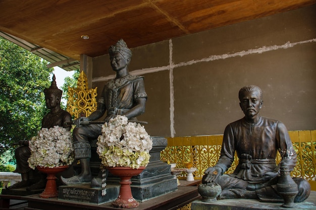 Photo statues of a man and a woman sit in a temple.