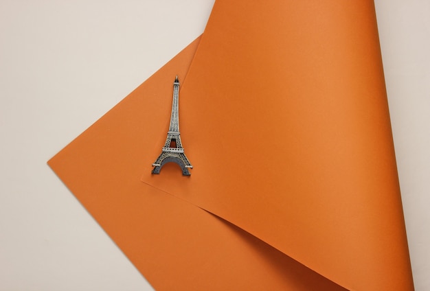 Statuette of the eiffel tower on a colored paper