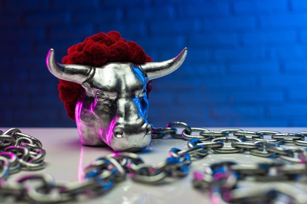 The statuette of a steel white metal bull with chains