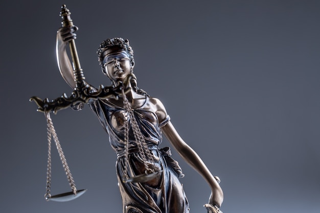 Statute of Justice. Bronze statue Lady Justice holding scales and sword.