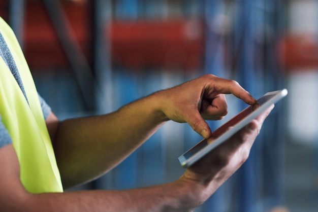 Photo stay connected stay safety compliant shot of a builder using a digital tablet while working at a construction site