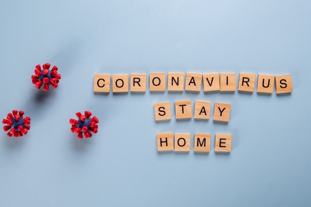 Stay home stay safe concept made up of wooden letters and models of covid-19 virus