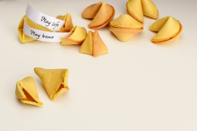 Stay home, Stay safe wishes in fortune cookies. Pile of Fortune cookies on a white background with copy space. Opened cookie.