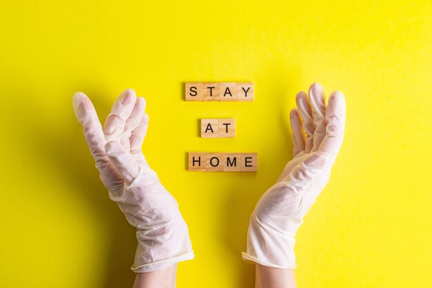 Stay at home text in hands in rubber gloves