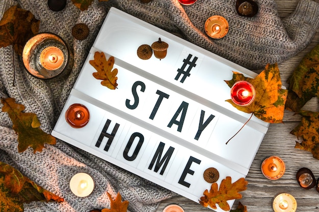 Photo stay at home text in your light box with a background of sweater candles dried flower decoration