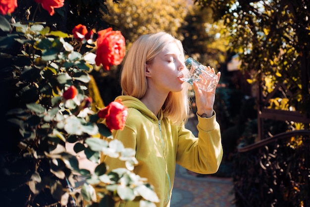 Stay hydrated. Pure enjoyment. Health care and hydration. Resort with mineral water sources. Enjoy every sip of crystal clear water in blooming garden. Girl drink water. Woman enjoy mineral water