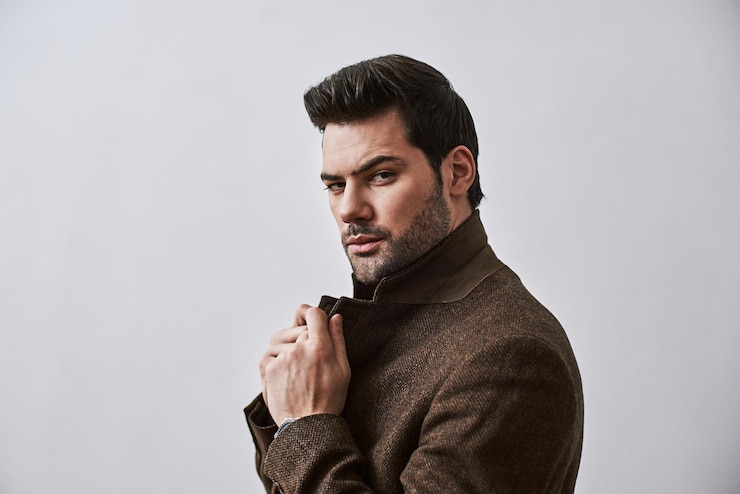 Photo stay strong stylish darkhaired man holding his jacket while standing over white background and