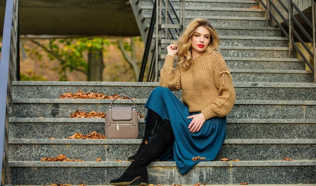 Staying beautiful any season girl blond hair autumn woman curly hair outdoor girl in corrugated skirt and sweater Pleated trend casual style student fall season female beauty Fashion model