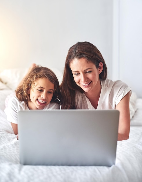 Staying occupied and entertained online Cropped shot of a mother and using a laptop together at home in the morning