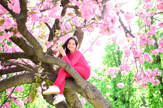 Staying stylish in spring Little girl in fashion wear in spring garden Fashionable young lady on flowering tree Pretty girl with fashion look Fashion clothing for spring