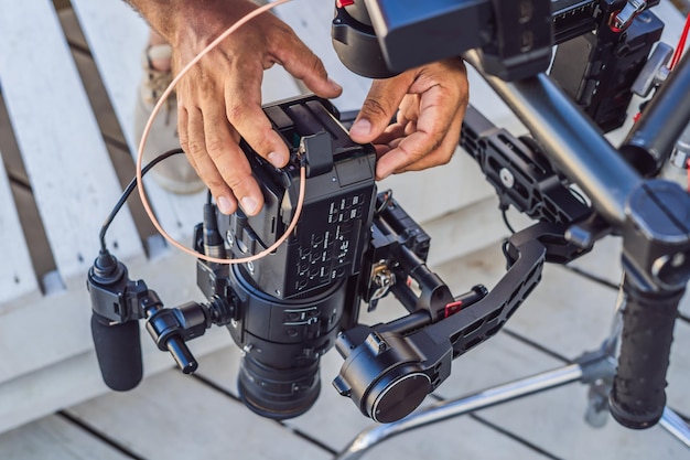 Steadicam-operator en zijn assistent bereiden camera en 3axis-stabilisatorgimbal voor op een commerciële shoot