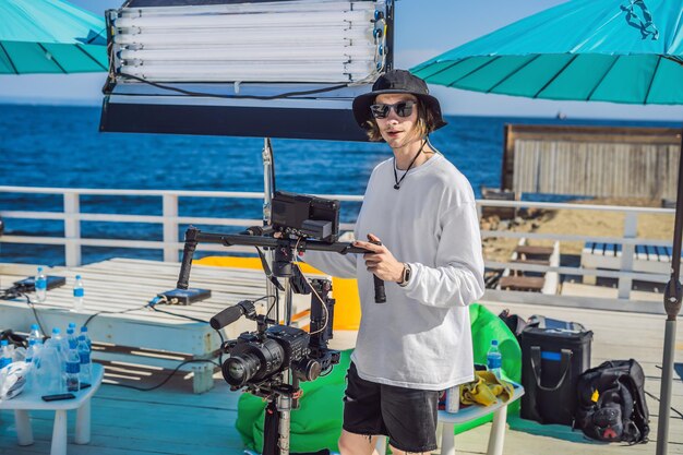 Steadicam operator and his assistant prepare camera and 3axis stabilizergimbal for a commercial shoot