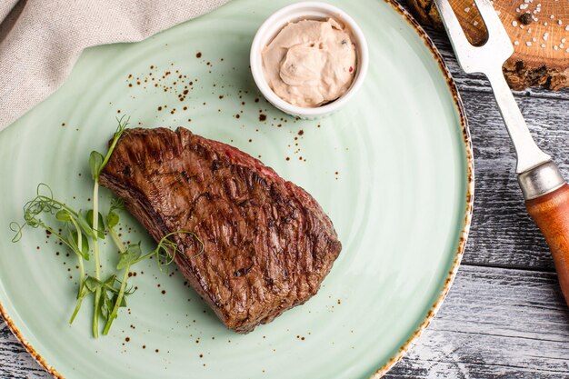 Foto bistecca di manzo bistecca di manzo alla griglia su uno sfondo bianco di legno