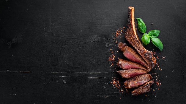 Steak on the bone tomahawk steak On a black wooden background Top view Free copy space