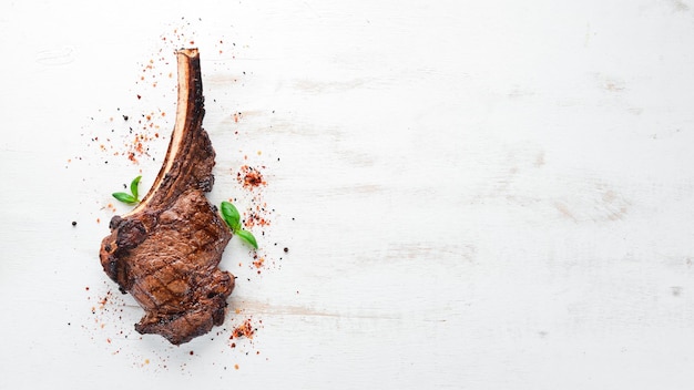 Steak on the bone tomahawk steak On a white wooden background Top view Free copy space