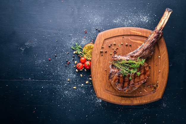 Steak on the bone Top view Free space for text On a wooden background