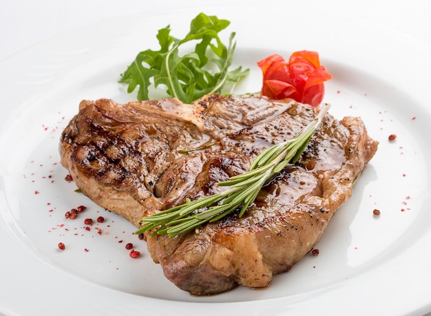 Steak bone with greens On a white plate