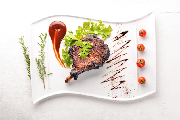 Steak on a bone with tomatoes and a hazelnut Steak Fiorentino On a wooden background Free space for your text Top view