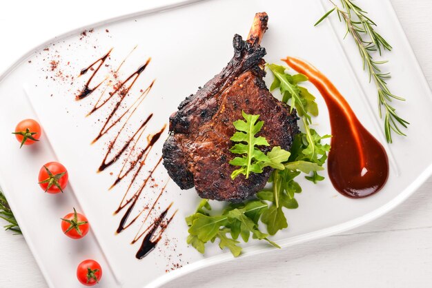 Steak on a bone with tomatoes and a hazelnut Steak Fiorentino On a wooden background Free space for your text Top view