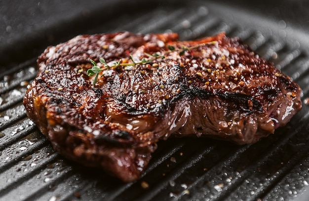 Steak from a fresh piece of marbled beef fried in a pan