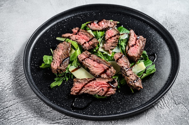 Steak salad with spinach, arugula and sliced beef flank steak