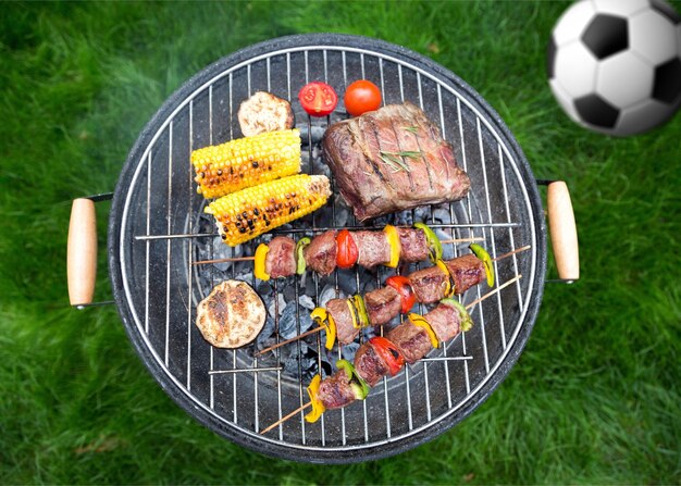 Steak, sausages and assorted fresh vegetables on grilling