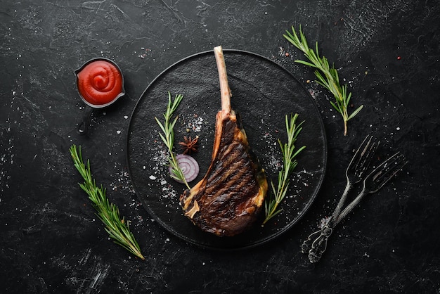 Steak Tomahawk on the bone grilled with rosemary and spices Top view Free space for your text