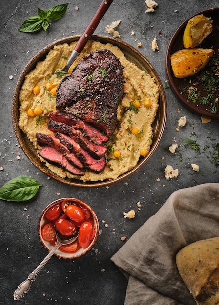 Foto steak top blade con hummus steak medio raro vista dall'alto