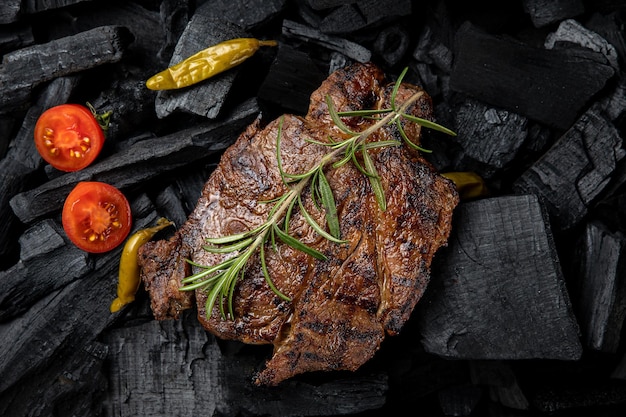 A steak with a sprig of rosemary on it