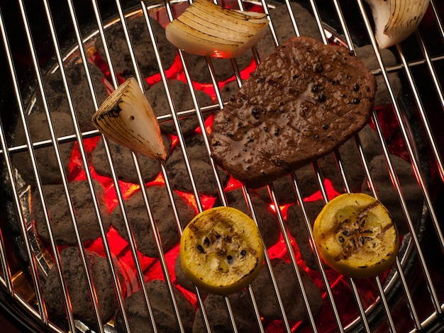 Steak with vegetables cooking on the grill.