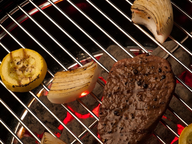 Steak with vegetables cooking on the grill.