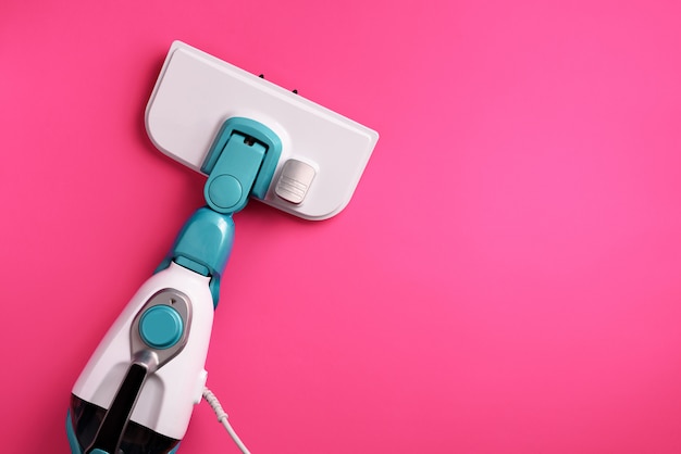 Steam cleaner mop on pink background. 