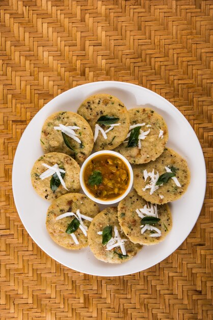 Steam cooked semolina cakes known as rava idli or idly. served with sambar and coconut chutney. selective focus