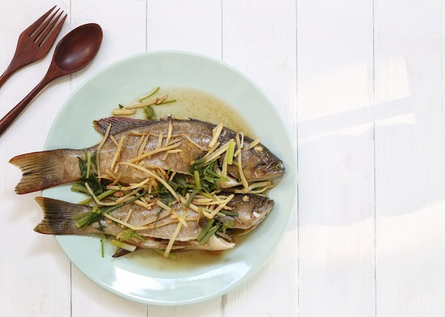 Photo steamed blue point grouper fish with soy sauce in white dish.