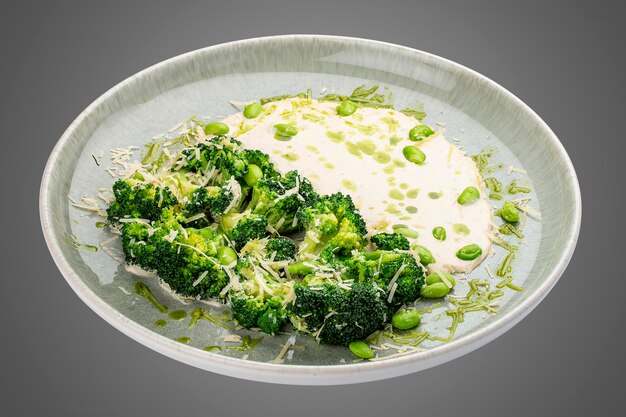 Foto broccoli al vapore con salsa di crema e parmesano isolato su uno sfondo bianco