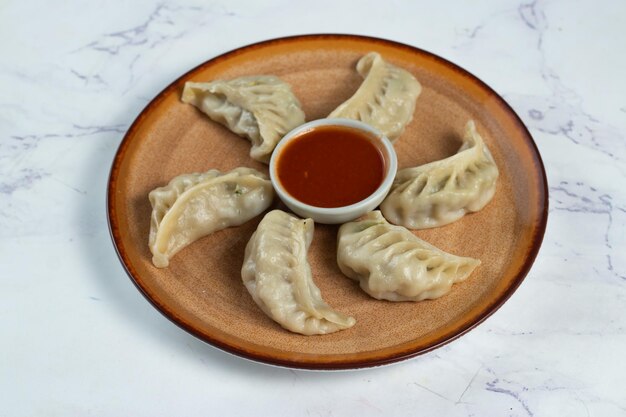 Steamed chicken mom wrap with ketchup served in a dish isolated on background top view