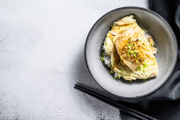 Steamed cod fillet with omelet and rice. White background.