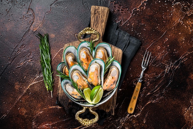 Steamed cooked Green mussels with herbs and spices in a skillet Dark background Top view