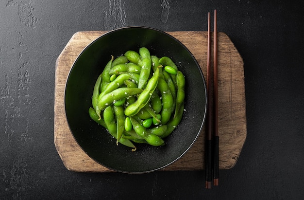 Steamed edamame soybeans on a black background view from above