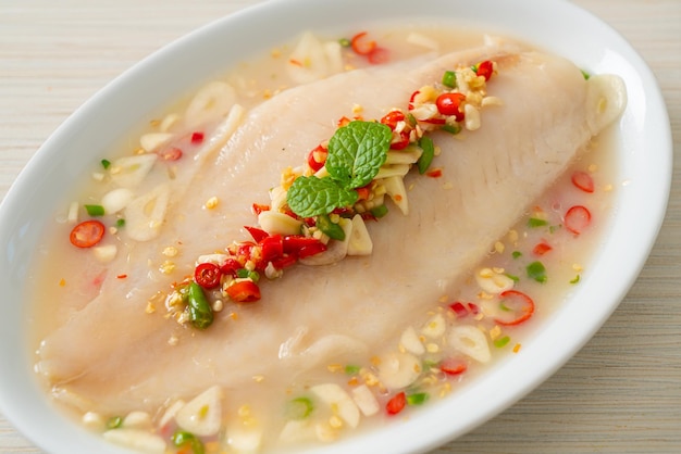 Steamed Fish in Spicy Lemon Sauce on white plate