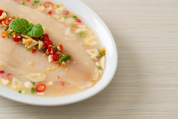 Steamed Fish in Spicy Lemon Sauce on white plate