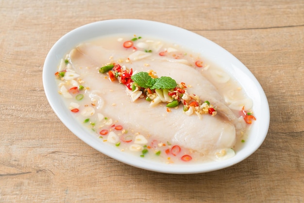 Steamed Fish in Spicy Lemon Sauce on white plate