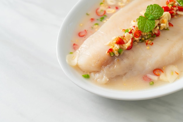 Steamed Fish in Spicy Lemon Sauce on white plate