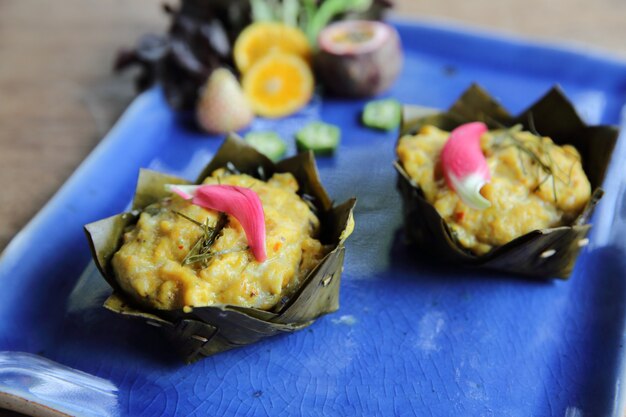 Steamed fish with curry paste on wood background