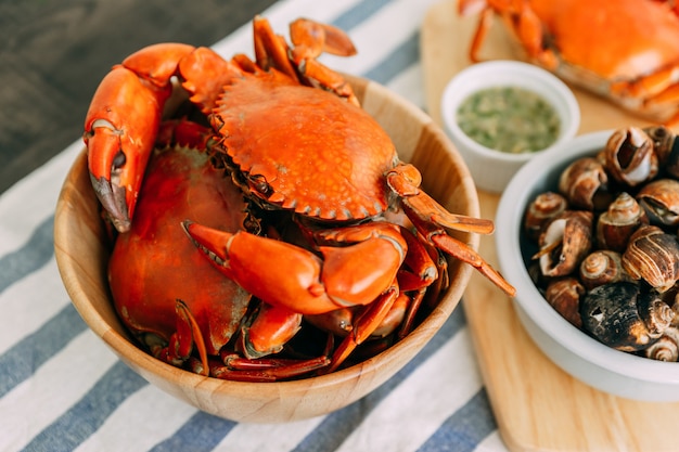 Steamed Giant Mud Crabs in wooden bowl served with Thai spicy seafood sauce.