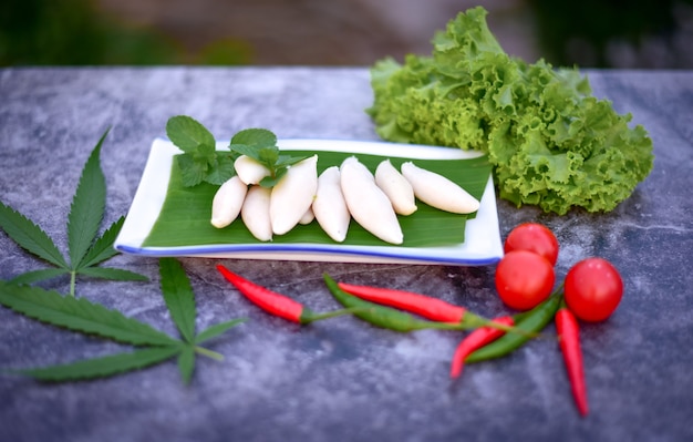 Foto polpette al vapore, foglie di canapa e verdure su fondo scuro