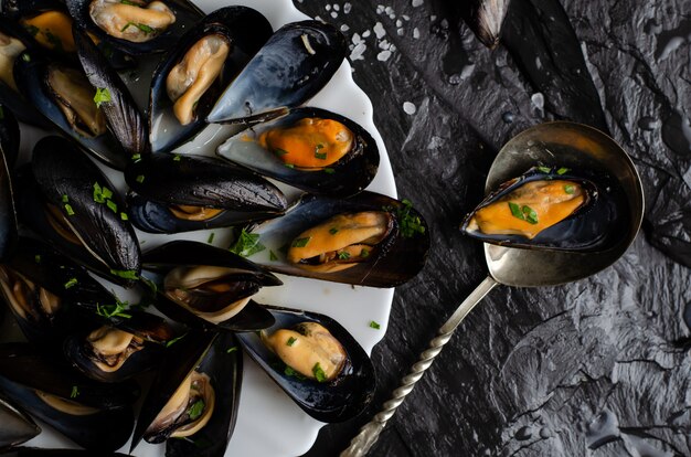 Steamed mussels with parsley. Mediterranean food concept. Top view, flat lay